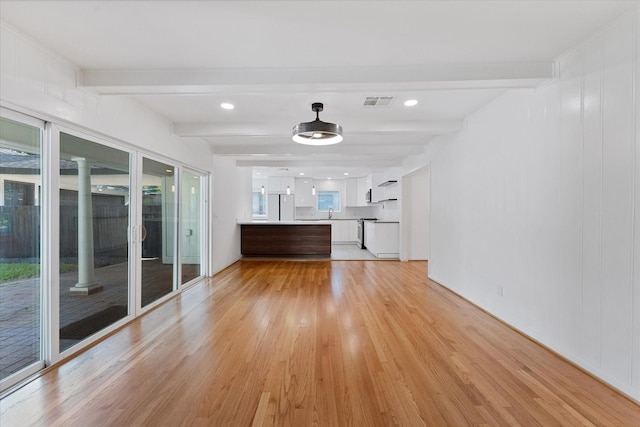 7807 Ella Lee Ln, Houston, TX 77063 - unfurnished living room featuring beam ceiling and light wood-type flooring