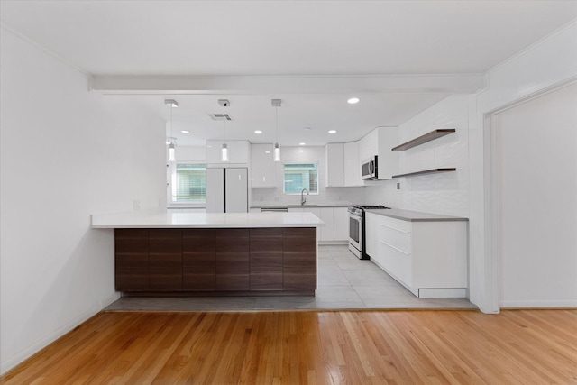 7807 Ella Lee Ln, Houston, TX 77063 - kitchen with appliances with stainless steel finishes, white cabinets, a peninsula, light wood-style flooring, and recessed lighting