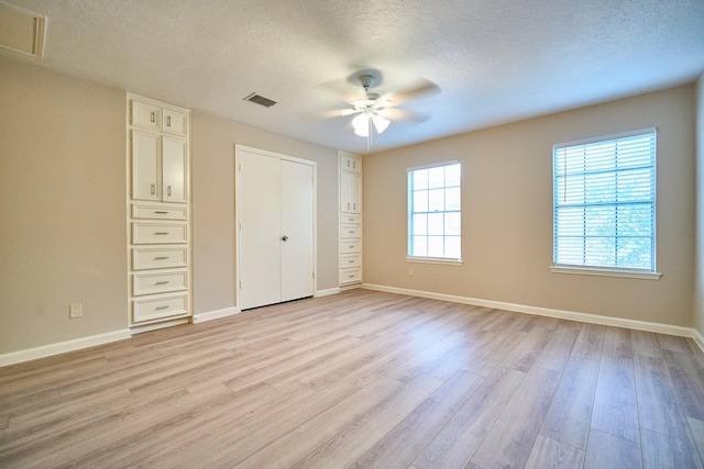 10818 Briar Forest Dr Unit 34, Houston, TX 77042 - unfurnished bedroom featuring light wood finished floors, a textured ceiling, a closet, and ceiling fan