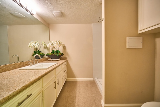 10818 Briar Forest Dr Unit 34, Houston, TX 77042 - bathroom featuring vanity, tiled shower, and a textured ceiling