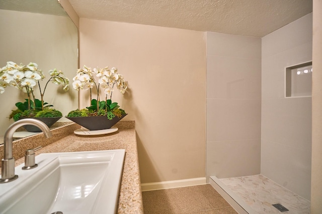 10818 Briar Forest Dr Unit 34, Houston, TX 77042 - bathroom with a textured ceiling, a tile shower, and vanity