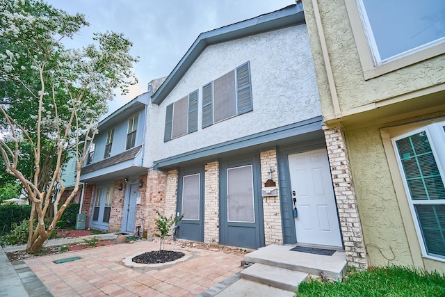 10818 Briar Forest Dr Unit 34, Houston, TX 77042 - view of front facade featuring stucco siding, brick siding, and a patio area