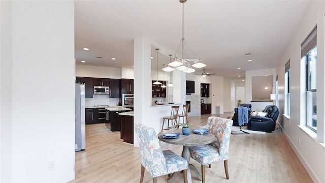 1767 Michigan St, Houston, TX 77006 - dining space with light wood-type flooring, a ceiling fan, recessed lighting, and a chandelier
