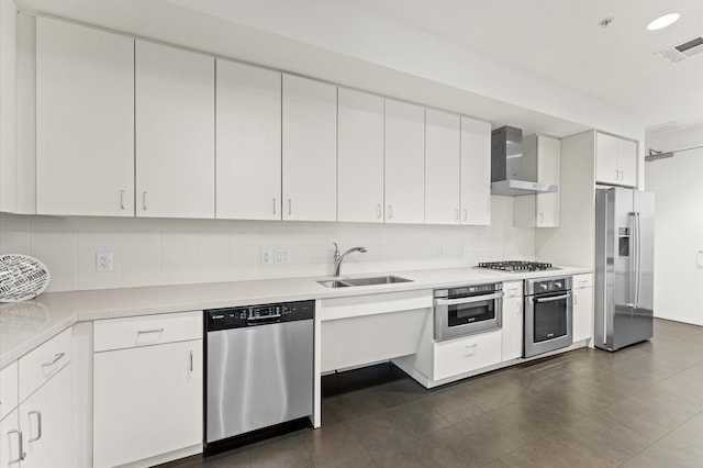 2207 Bancroft St Unit 1104, Houston, TX 77027 - kitchen featuring stainless steel appliances, wall chimney range hood, light countertops, decorative backsplash, and white cabinetry