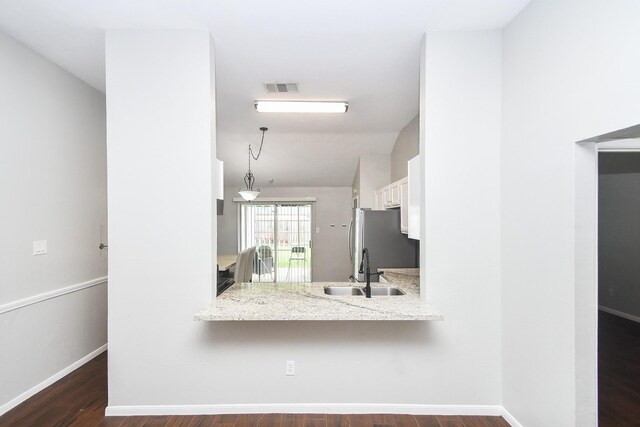 16810 Rockstone, Houston, TX 77084 - kitchen featuring freestanding refrigerator, white cabinetry, dark wood finished floors, a peninsula, and vaulted ceiling