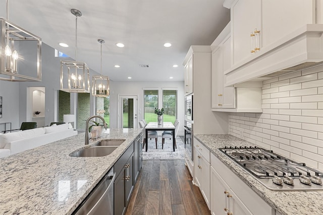 14251 Archer County Trl, Cypress, TX 77429 - kitchen featuring appliances with stainless steel finishes, dark wood-style flooring, white cabinetry, open floor plan, and custom exhaust hood