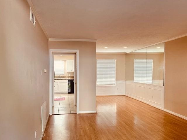7900 Westheimer Rd Unit 143, Houston, TX 77063 - empty room with crown molding, wood finished floors, and a wainscoted wall