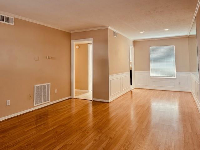 7900 Westheimer Rd Unit 143, Houston, TX 77063 - spare room with light wood-style floors, crown molding, and a wainscoted wall