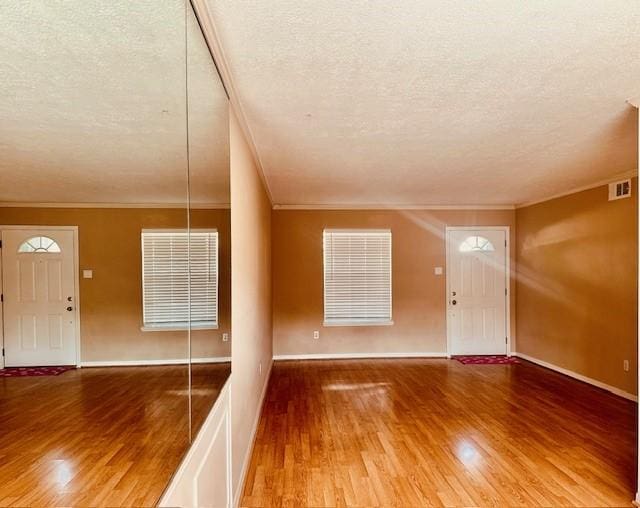 7900 Westheimer Rd Unit 143, Houston, TX 77063 - foyer entrance featuring a textured ceiling, wood finished floors, and ornamental molding