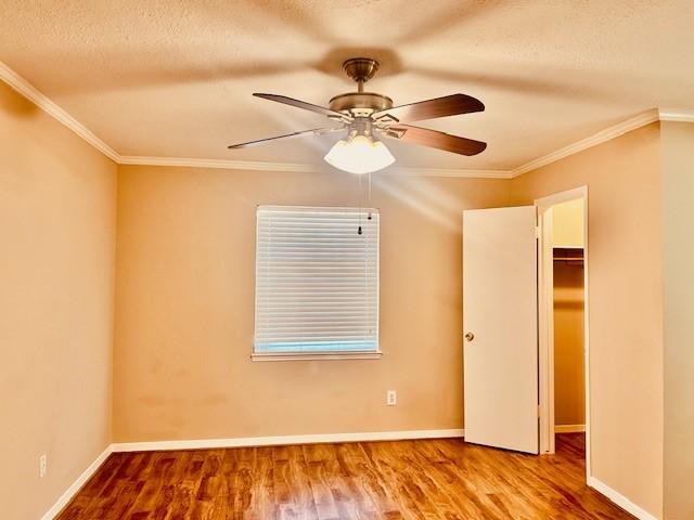 7900 Westheimer Rd Unit 143, Houston, TX 77063 - unfurnished bedroom featuring wood finished floors, crown molding, a textured ceiling, ceiling fan, and a closet