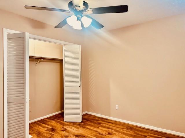 7900 Westheimer Rd Unit 143, Houston, TX 77063 - unfurnished bedroom with wood finished floors, a closet, and a ceiling fan