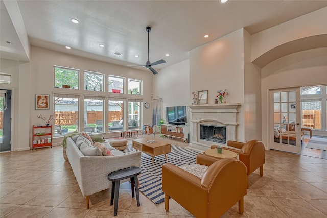 5918 Emmit Creek Ln, Sugar Land, TX 77479 - living area featuring a towering ceiling, light tile patterned floors, healthy amount of natural light, a ceiling fan, and a fireplace with raised hearth