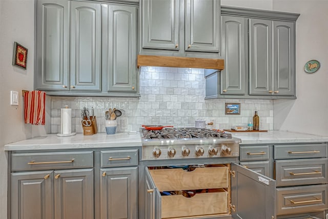 5918 Emmit Creek Ln, Sugar Land, TX 77479 - kitchen featuring gray cabinetry, stainless steel gas stovetop, tasteful backsplash, and light stone countertops