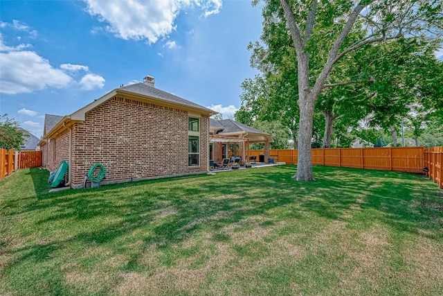 5918 Emmit Creek Ln, Sugar Land, TX 77479 - back of property with brick siding, a fenced backyard, a chimney, and a patio
