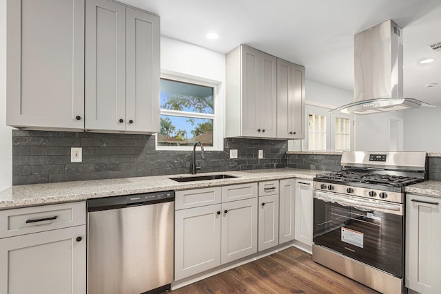 8419 Sterlingshire St, Houston, TX 77078 - kitchen with appliances with stainless steel finishes, island range hood, dark wood finished floors, decorative backsplash, and recessed lighting