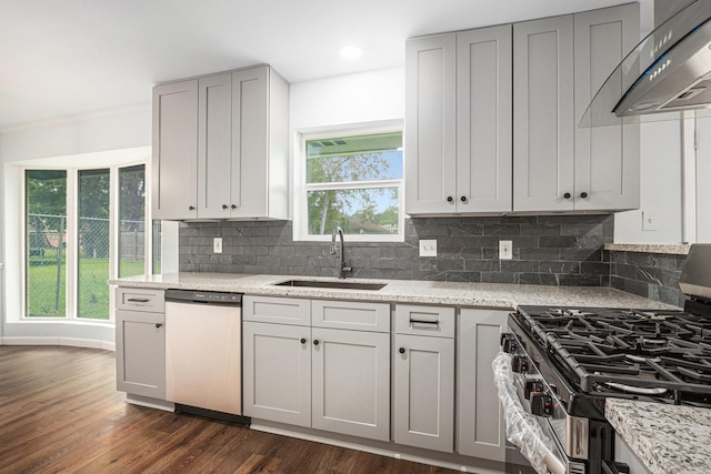 8419 Sterlingshire St, Houston, TX 77078 - kitchen with stainless steel appliances, wall chimney exhaust hood, decorative backsplash, dark wood-type flooring, and light stone countertops