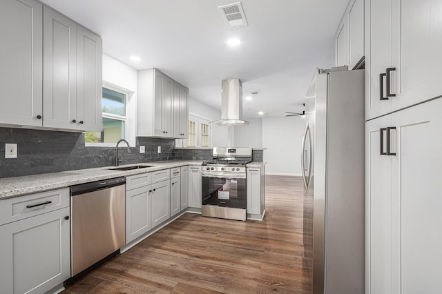 8419 Sterlingshire St, Houston, TX 77078 - kitchen featuring stainless steel appliances, island exhaust hood, dark wood finished floors, backsplash, and recessed lighting