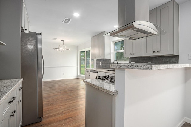 8419 Sterlingshire St, Houston, TX 77078 - kitchen with island range hood, appliances with stainless steel finishes, backsplash, dark wood finished floors, and a chandelier