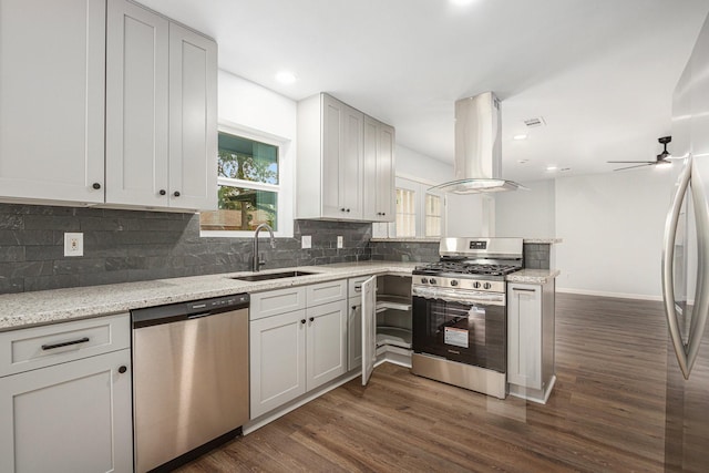 8419 Sterlingshire St, Houston, TX 77078 - kitchen featuring stainless steel appliances, island range hood, a peninsula, dark wood-style flooring, and recessed lighting