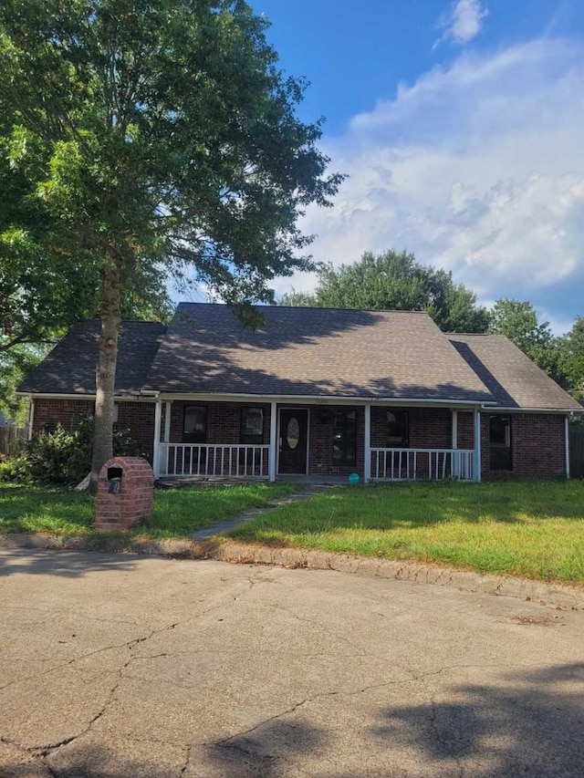 12206 Fairhaven Ln, Montgomery, TX 77356 - single story home with a porch, brick siding, a front lawn, and a shingled roof