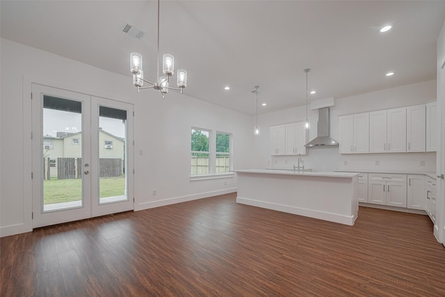515 Briarcliff Dr, Houston, TX 77076 - kitchen with wall chimney range hood, dark wood-style flooring, french doors, white cabinets, and light countertops
