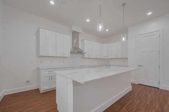 515 Briarcliff Dr, Houston, TX 77076 - kitchen featuring wall chimney range hood, dark wood finished floors, a kitchen island with sink, recessed lighting, and white cabinets