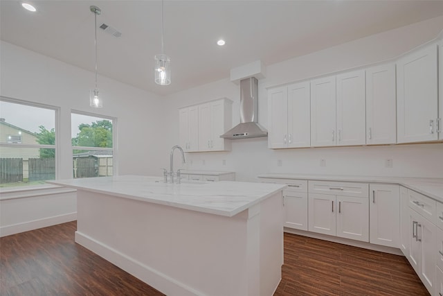 515 Briarcliff Dr, Houston, TX 77076 - kitchen with wall chimney range hood, white cabinets, dark wood finished floors, light stone countertops, and recessed lighting
