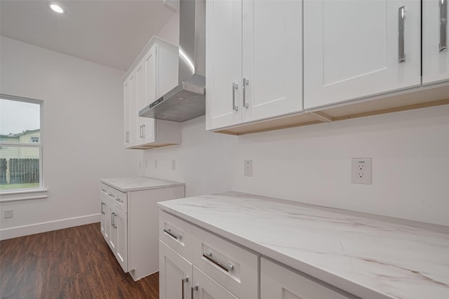 515 Briarcliff Dr, Houston, TX 77076 - kitchen with wall chimney range hood, dark wood finished floors, light stone counters, white cabinetry, and recessed lighting