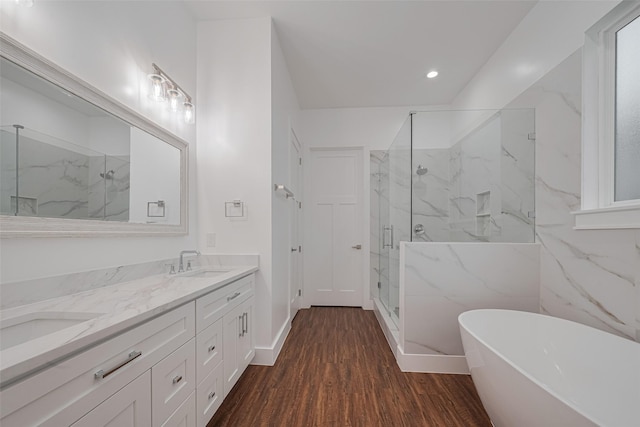 515 Briarcliff Dr, Houston, TX 77076 - bathroom featuring a marble finish shower, double vanity, a freestanding bath, wood finished floors, and recessed lighting