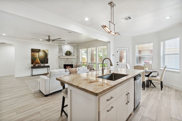 13826 Swan Hollow Ln, Houston, TX 77041 - kitchen with dishwasher, a high end fireplace, ornamental molding, arched walkways, and an island with sink