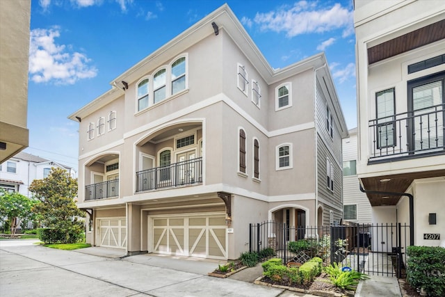 4205 Dickson St, Houston, TX 77007 - townhome / multi-family property featuring stucco siding, a garage, driveway, and a gate