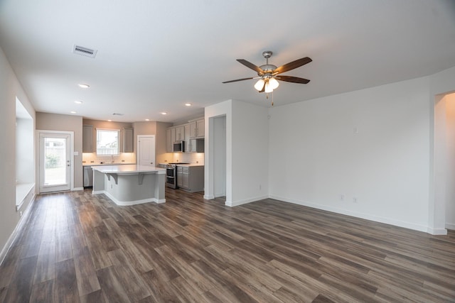 8034 Whisper Grove Dr, Magnolia, TX 77354 - kitchen with stainless steel appliances, gray cabinets, a kitchen bar, dark wood finished floors, and recessed lighting