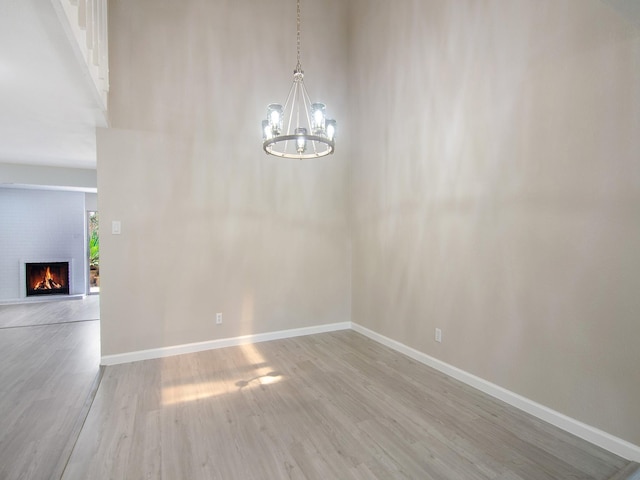 11624 Village Place Dr Unit 327, Houston, TX 77077 - unfurnished dining area featuring light wood-style flooring, a chandelier, and a brick fireplace