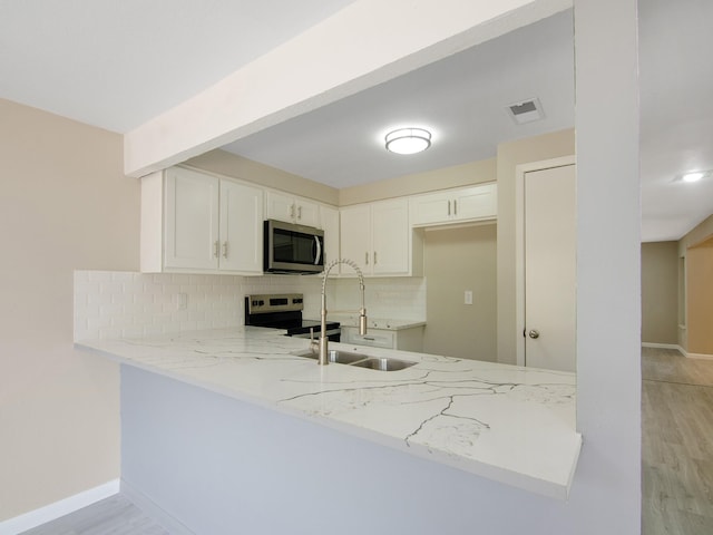 11624 Village Place Dr Unit 327, Houston, TX 77077 - kitchen featuring stainless steel appliances, a peninsula, tasteful backsplash, and light stone counters