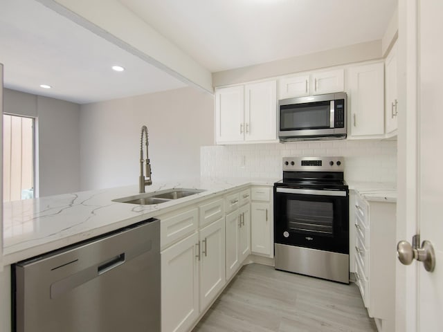 11624 Village Place Dr Unit 327, Houston, TX 77077 - kitchen featuring stainless steel appliances, light stone counters, decorative backsplash, white cabinets, and recessed lighting