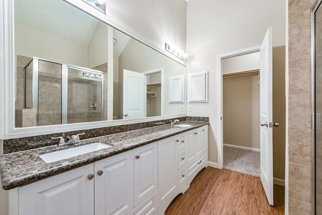 4611 Green Trail Dr, Houston, TX 77084 - bathroom with a walk in closet, double vanity, a stall shower, and wood finished floors