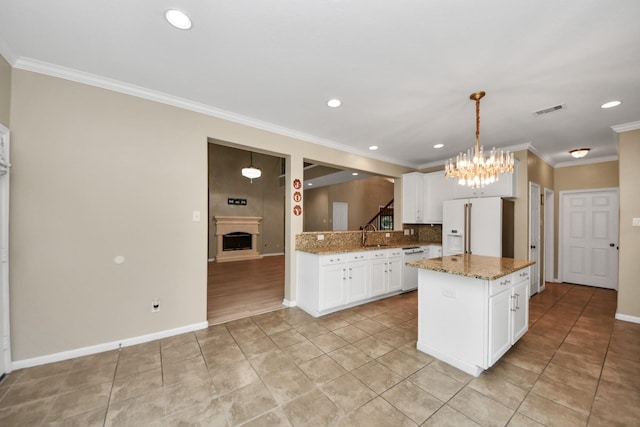 20902 Montana Bend Ln, Cypress, TX 77433 - kitchen with white appliances, a chandelier, light tile patterned flooring, backsplash, and a fireplace