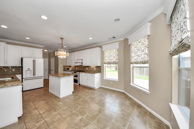 20902 Montana Bend Ln, Cypress, TX 77433 - kitchen with white appliances, ornamental molding, backsplash, a chandelier, and a center island