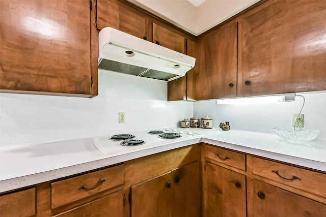 10410 Collingswood Rd, La Porte, TX 77571 - kitchen featuring under cabinet range hood, white electric stovetop, and brown cabinets