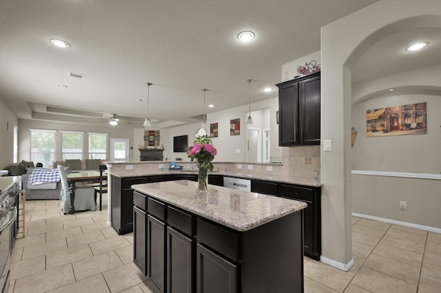 7455 Durango Creek Dr, Magnolia, TX 77354 - kitchen with open floor plan, a ceiling fan, a peninsula, light tile patterned flooring, and light stone counters