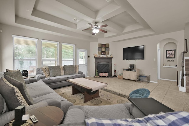 7455 Durango Creek Dr, Magnolia, TX 77354 - living area featuring light tile patterned floors, coffered ceiling, ceiling fan, a fireplace with raised hearth, and arched walkways