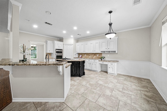 2452 Ripplewood Dr, Conroe, TX 77384 - kitchen featuring a kitchen breakfast bar, light stone counters, stainless steel double oven, ornamental molding, and backsplash