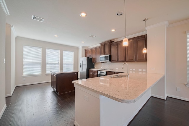 10004 Spring Shadows Park Cir, Houston, TX 77080 - kitchen featuring stainless steel appliances, a center island, tasteful backsplash, dark wood-style flooring, and ornamental molding