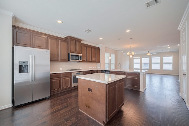 10004 Spring Shadows Park Cir, Houston, TX 77080 - kitchen with stainless steel appliances, a peninsula, light countertops, dark wood-type flooring, and a kitchen island