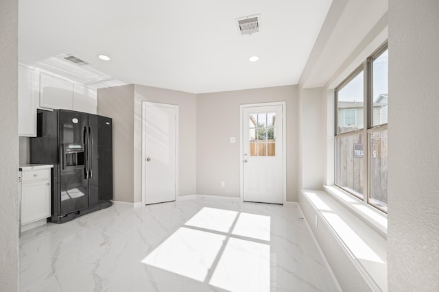 18935 Remington Bend Dr, Houston, TX 77073 - kitchen with black refrigerator with ice dispenser, white cabinets, recessed lighting, and light marble finish floors