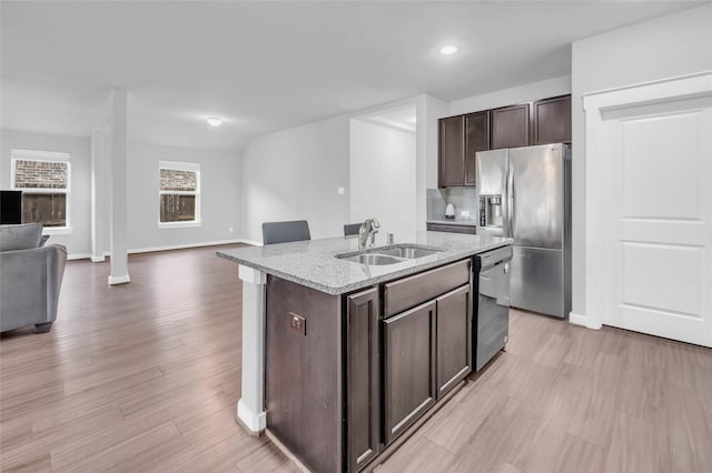 12326 Sabine Point Dr, Humble, TX 77346 - kitchen featuring stainless steel refrigerator with ice dispenser, open floor plan, dishwashing machine, dark brown cabinetry, and light stone counters