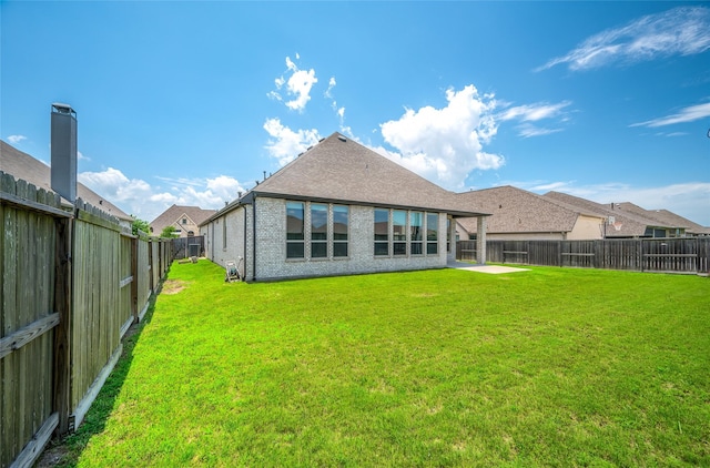 30218 Indigo Falls Dr, Brookshire, TX 77423 - rear view of house with a fenced backyard, brick siding, and a shingled roof