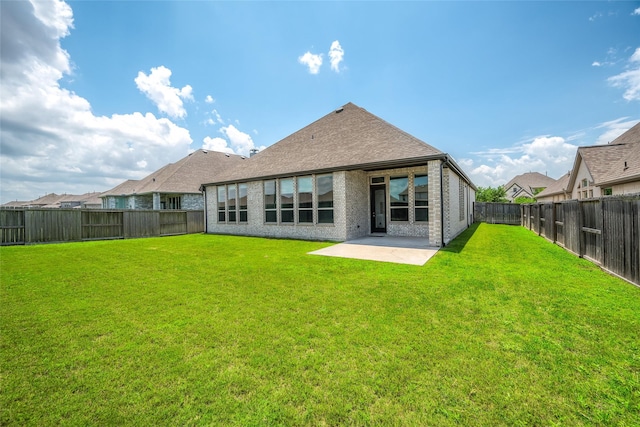 30218 Indigo Falls Dr, Brookshire, TX 77423 - back of property featuring a fenced backyard, a patio, brick siding, and roof with shingles