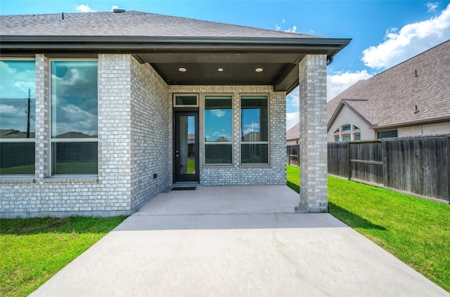 30218 Indigo Falls Dr, Brookshire, TX 77423 - doorway to property featuring brick siding, a patio, and a shingled roof