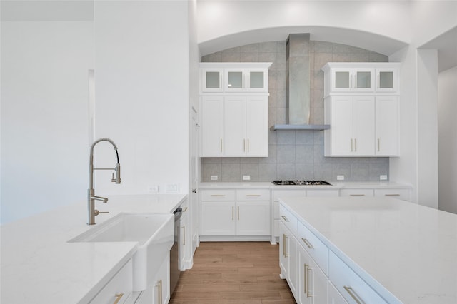 30218 Indigo Falls Dr, Brookshire, TX 77423 - kitchen featuring wall chimney range hood, gas stovetop, light countertops, and white cabinetry